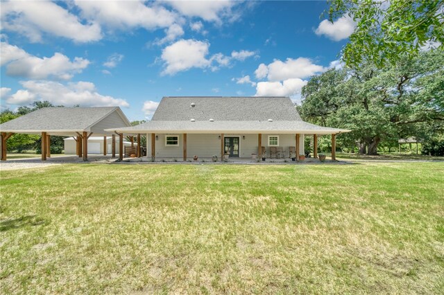 rear view of property with gravel driveway and a yard