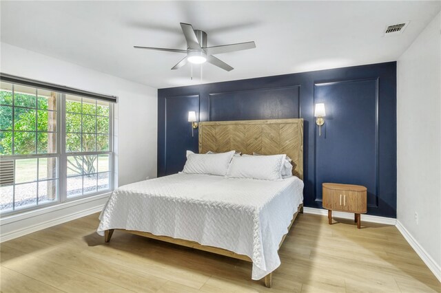 bedroom with a ceiling fan, visible vents, baseboards, and light wood-style floors