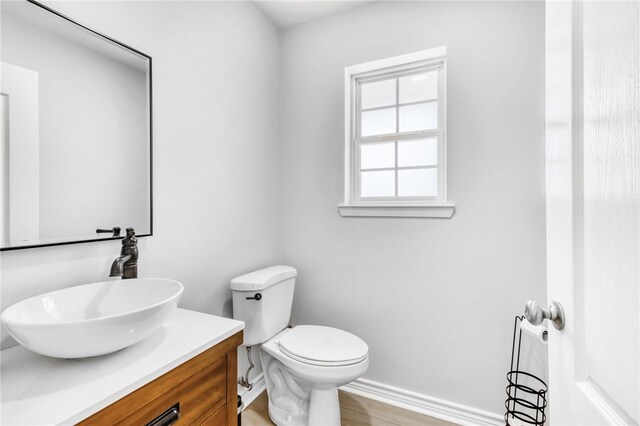 bathroom with vanity, toilet, and baseboards