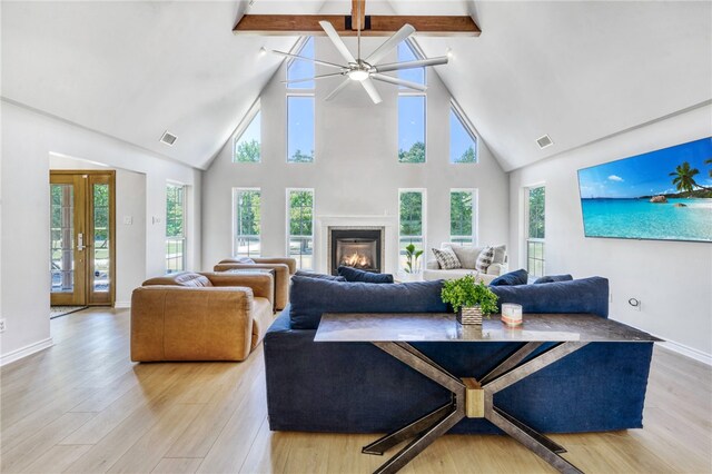living area featuring beam ceiling, ceiling fan, high vaulted ceiling, and light wood-style floors