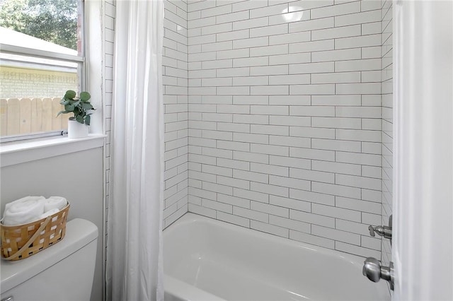 bathroom featuring shower / bath combo and toilet