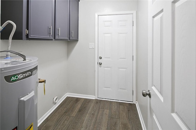 clothes washing area featuring cabinets, electric water heater, and dark wood-type flooring