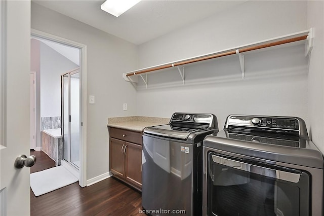 clothes washing area with dark hardwood / wood-style floors, cabinets, and washing machine and clothes dryer