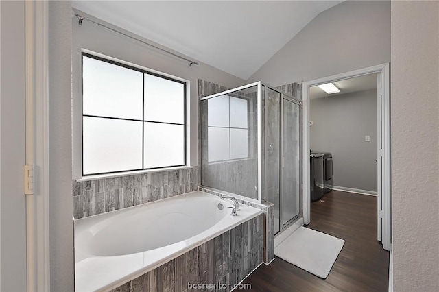 bathroom featuring separate washer and dryer, vaulted ceiling, hardwood / wood-style flooring, and a healthy amount of sunlight