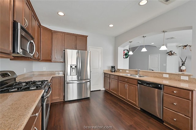 kitchen featuring light stone countertops, sink, stainless steel appliances, dark hardwood / wood-style floors, and decorative light fixtures