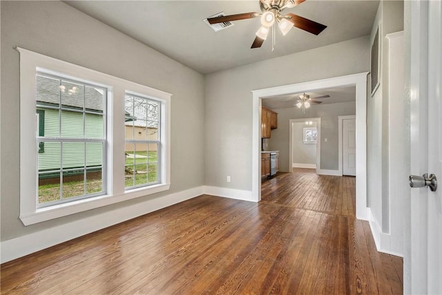 empty room with ceiling fan, wood finished floors, and baseboards