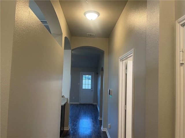 833 Mockingbird St, Navasota, TX 77868 - hall featuring arched walkways, dark wood-type flooring, and baseboards