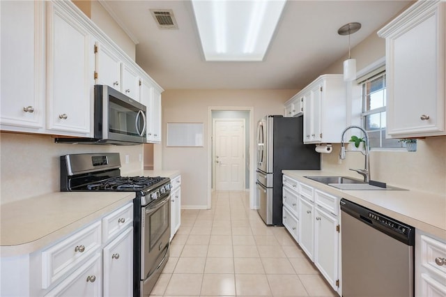 kitchen with appliances with stainless steel finishes, white cabinetry, pendant lighting, and sink