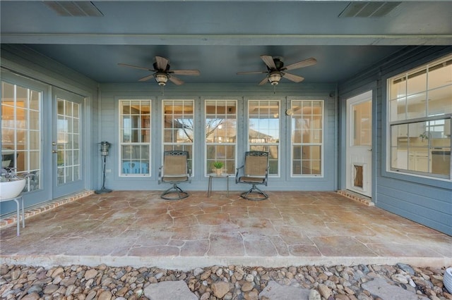 unfurnished sunroom with ceiling fan