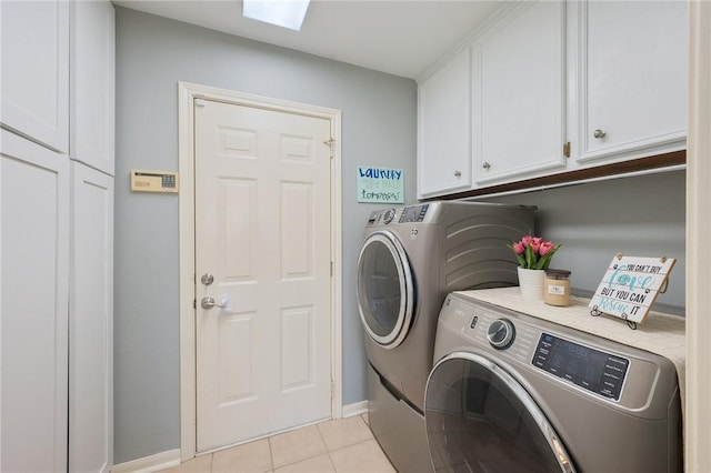 washroom with cabinets, independent washer and dryer, light tile patterned floors, and a skylight