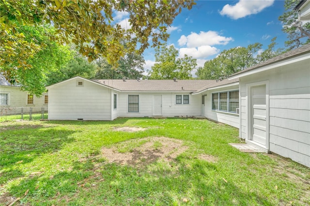 rear view of property with a lawn