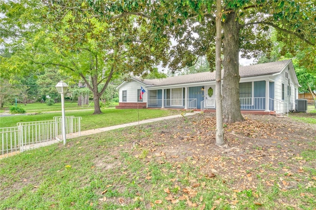 ranch-style house featuring a sunroom, cooling unit, and a front yard