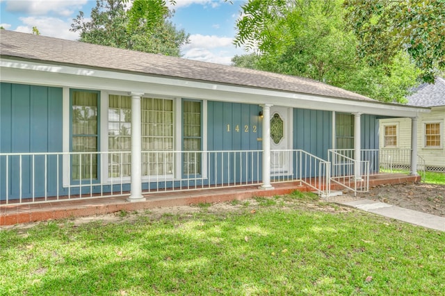 single story home featuring a front lawn and covered porch