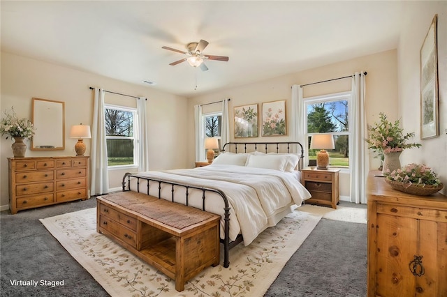 bedroom with visible vents, light colored carpet, baseboards, and a ceiling fan
