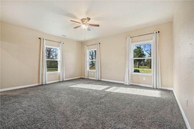 spare room featuring visible vents, carpet floors, baseboards, and ceiling fan