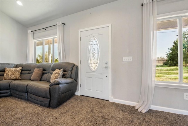foyer entrance with plenty of natural light, carpet flooring, and baseboards