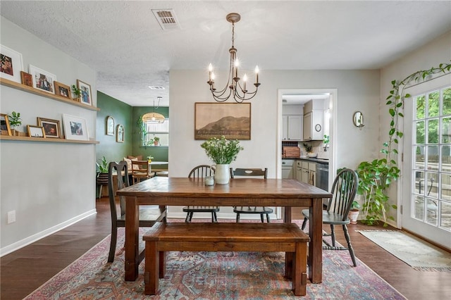 dining space with an inviting chandelier, visible vents, a wealth of natural light, and dark wood-style floors