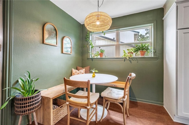 dining area featuring baseboards, wood finished floors, and breakfast area