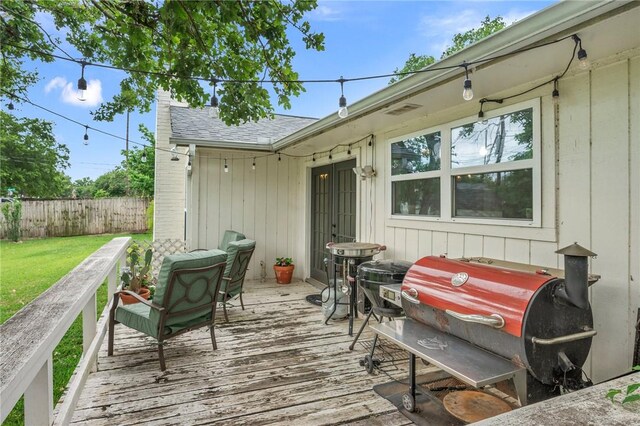 wooden deck with fence, a lawn, and grilling area