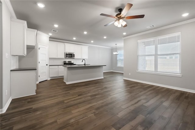 6434 Raleigh Loop, College Station, TX 77845 - kitchen featuring appliances with stainless steel finishes, dark countertops, crown molding, a ceiling fan, and dark wood-style floors