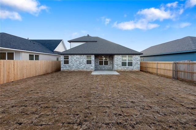 6434 Raleigh Loop, College Station, TX 77845 - back of property with a patio, a fenced backyard, stone siding, and a shingled roof
