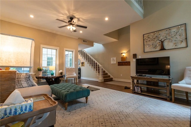 living room featuring ceiling fan, ornamental molding, and hardwood / wood-style flooring