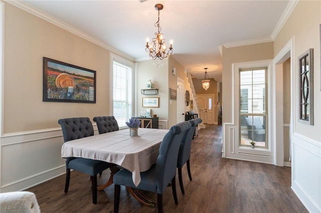 dining room with plenty of natural light, dark hardwood / wood-style flooring, ornamental molding, and an inviting chandelier