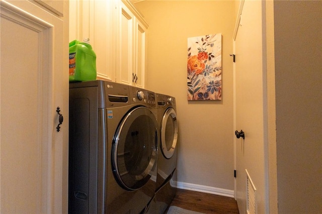 laundry room with separate washer and dryer, dark hardwood / wood-style flooring, and cabinets