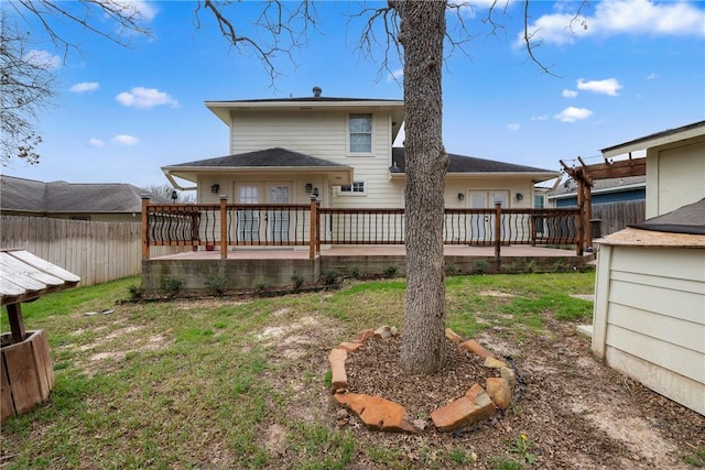 back of house with a wooden deck and a lawn