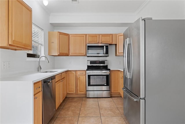 kitchen featuring appliances with stainless steel finishes, light brown cabinetry, sink, ornamental molding, and light tile patterned floors