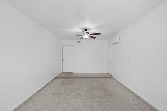 carpeted spare room with a wall mounted air conditioner, a textured ceiling, and ceiling fan