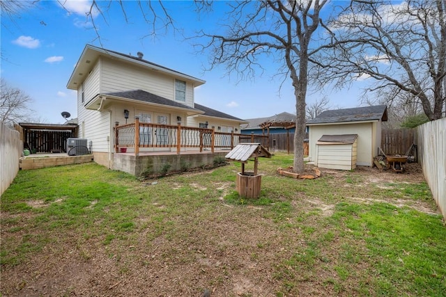 rear view of property with a yard, central AC unit, a deck, and a shed