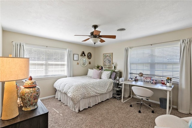 bedroom with visible vents, baseboards, carpet floors, a textured ceiling, and a ceiling fan