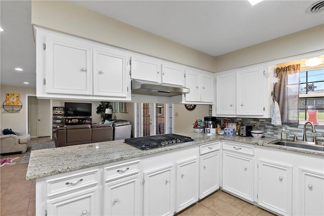 kitchen featuring visible vents, a sink, stainless steel gas stovetop, under cabinet range hood, and white cabinetry