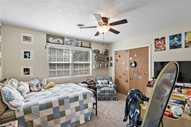 carpeted bedroom featuring a textured ceiling and a ceiling fan