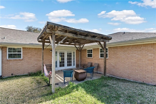 back of house with a pergola, a shingled roof, french doors, a patio area, and brick siding