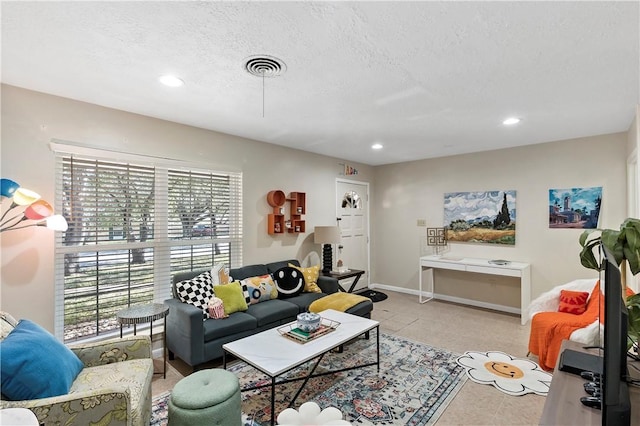 living area with recessed lighting, visible vents, baseboards, and a textured ceiling