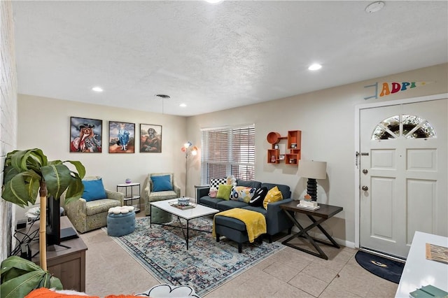 living area featuring light tile patterned floors, recessed lighting, a textured ceiling, and baseboards