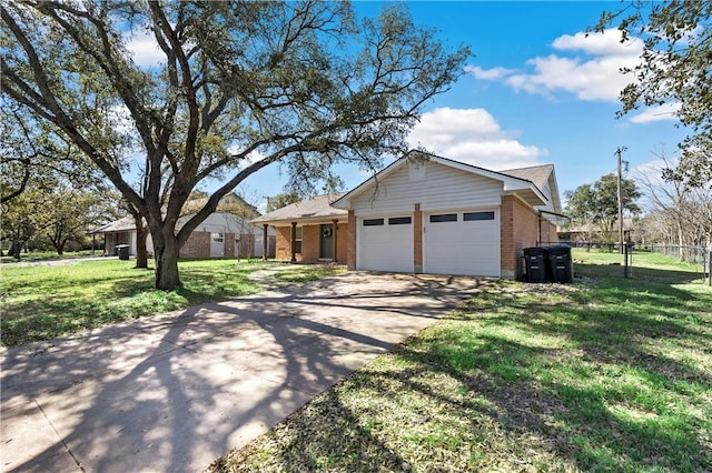 view of front of property with driveway, fence, a front yard, a garage, and brick siding