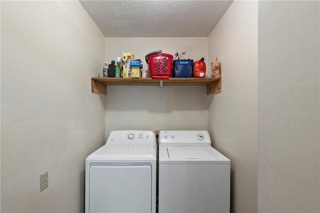 clothes washing area featuring washer and dryer, a textured ceiling, and laundry area