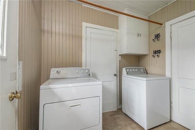 1103 Edgewood Dr, Bryan, TX 77802 - laundry area featuring washing machine and clothes dryer, wooden walls, and light tile patterned floors