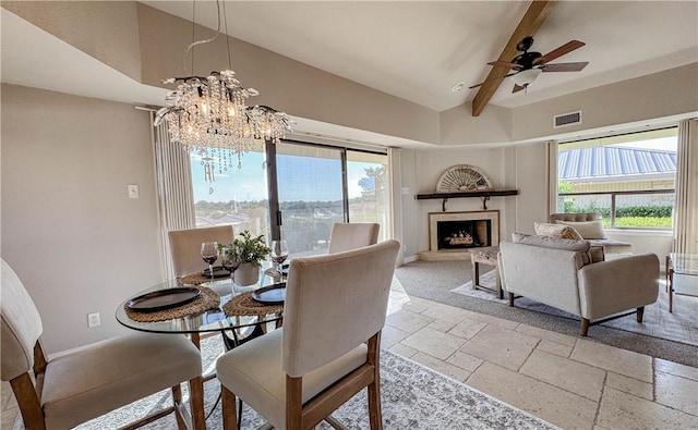 1406 Broken Hls Unit 14, Horseshoe Bay, TX 78657 - dining area featuring stone tile flooring, a chandelier, a fireplace with raised hearth, a ceiling fan, and baseboards