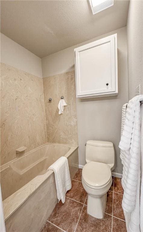 1406 Broken Hls Unit 14, Horseshoe Bay, TX 78657 - full bathroom featuring a tub with marble appearance, toilet, tile patterned flooring, and baseboards