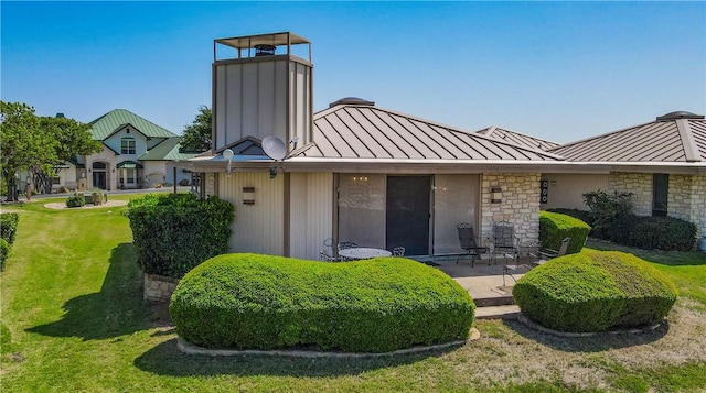 1406 Broken Hls Unit 14, Horseshoe Bay, TX 78657 - back of house with a standing seam roof, metal roof, a yard, a patio area, and stone siding