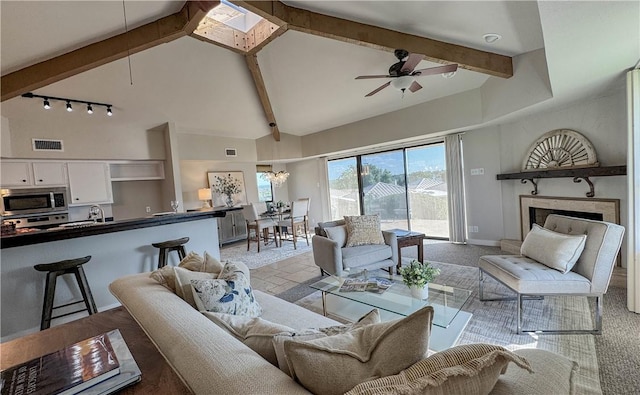 1406 Broken Hls Unit 14, Horseshoe Bay, TX 78657 - living room featuring track lighting, a ceiling fan, beam ceiling, high vaulted ceiling, and light carpet