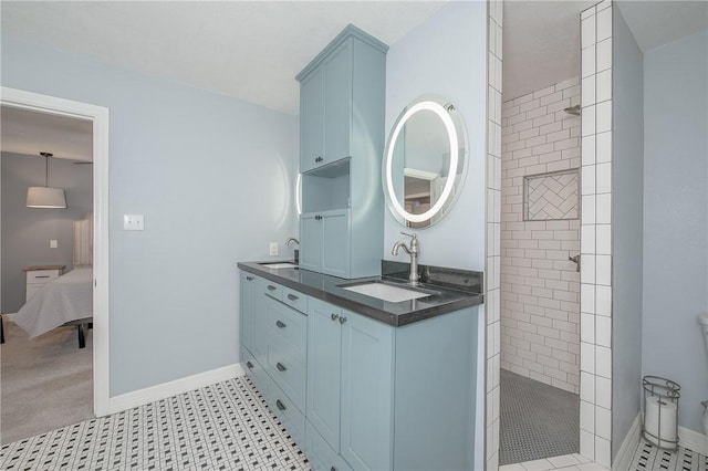 bathroom featuring tile patterned flooring, vanity, and tiled shower