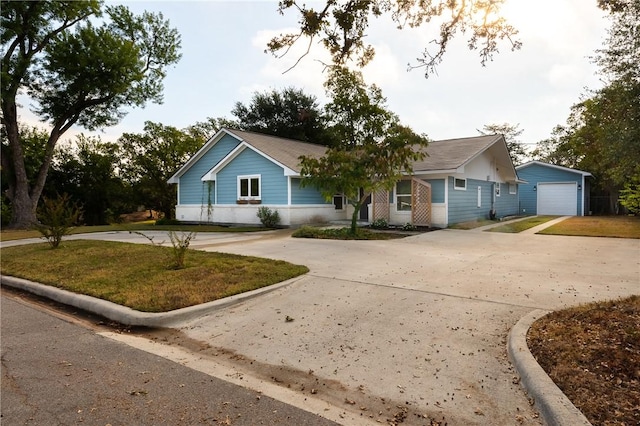 view of front facade with a front yard, a garage, and an outdoor structure