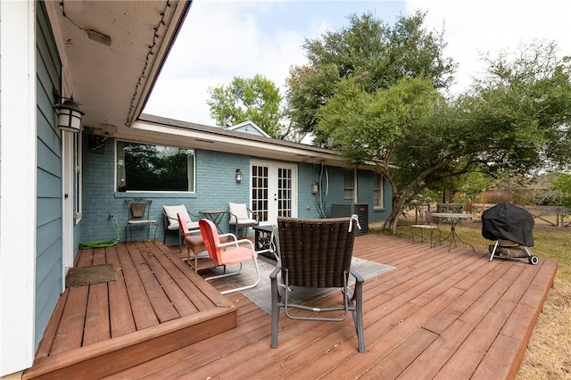 wooden deck with area for grilling, cooling unit, and french doors