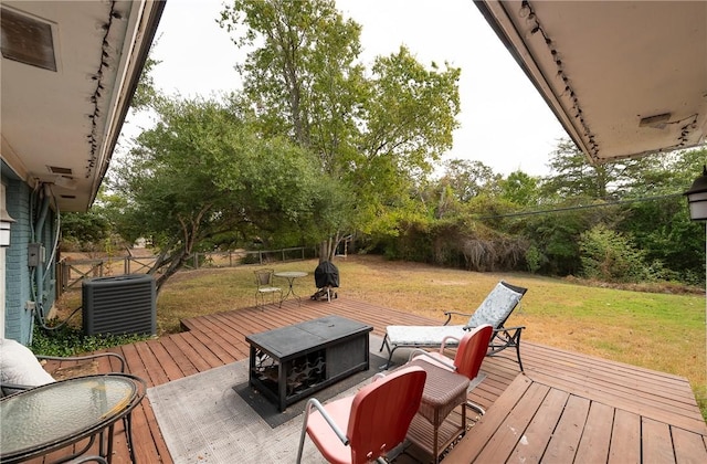 wooden terrace featuring cooling unit and a lawn