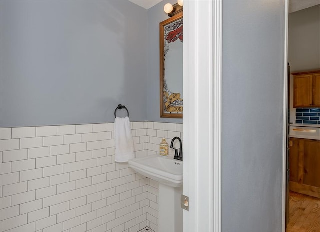 bathroom featuring hardwood / wood-style floors and tile walls